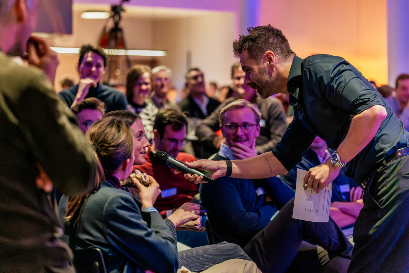 De moderator geeft de microfoon door aan iemand in het publiek